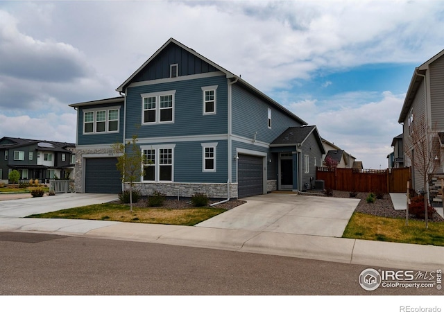4424 Haymill Ct, Timnath, CO 80547 - craftsman-style home with stone siding, fence, driveway, board and batten siding, and a garage