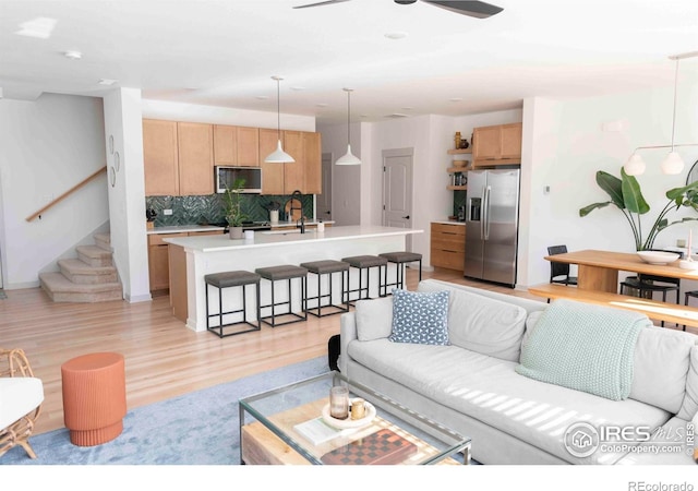 4424 Haymill Ct, Timnath, CO 80547 - living room with light wood-type flooring, a ceiling fan, and stairway