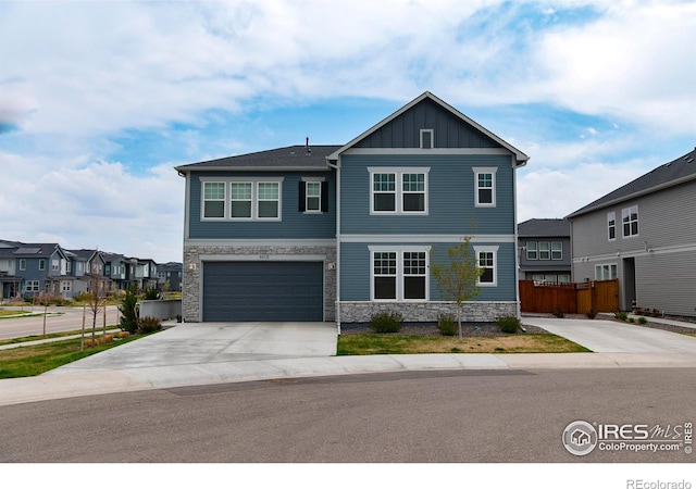 4424 Haymill Ct, Timnath, CO 80547 - view of front of property with stone siding, board and batten siding, concrete driveway, fence, and a garage