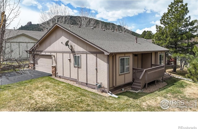 711 Eagle Ln, Estes Park, CO 80517 - view of home's exterior featuring a lawn, a deck, a garage, aphalt driveway, and a shingled roof