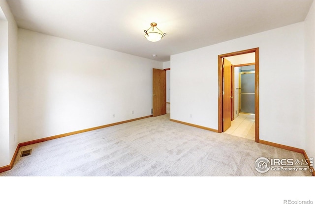711 Eagle Ln, Estes Park, CO 80517 - unfurnished bedroom featuring visible vents, baseboards, ensuite bath, and light carpet