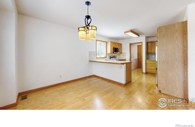 711 Eagle Ln, Estes Park, CO 80517 - kitchen with visible vents, light countertops, light wood finished floors, a peninsula, and stainless steel appliances