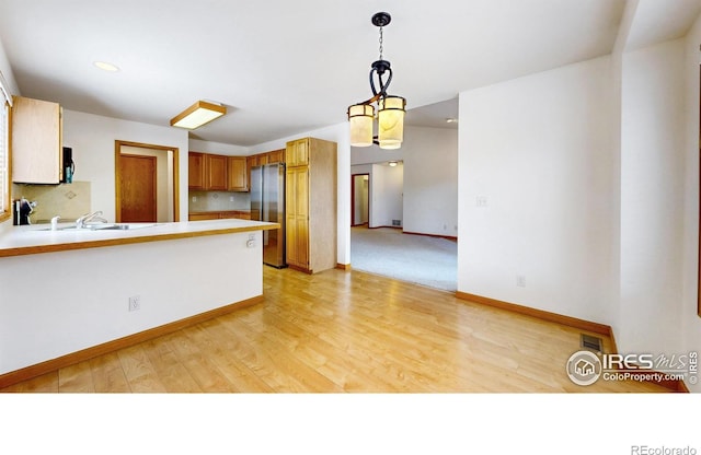 711 Eagle Ln, Estes Park, CO 80517 - kitchen with a sink, light countertops, freestanding refrigerator, a peninsula, and tasteful backsplash