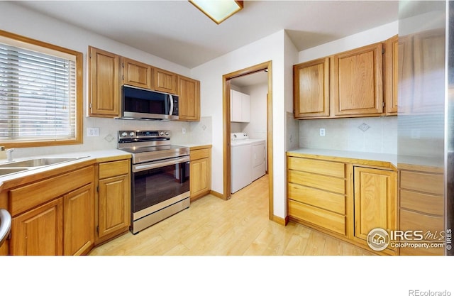711 Eagle Ln, Estes Park, CO 80517 - kitchen with separate washer and dryer, decorative backsplash, stainless steel appliances, and light wood-type flooring