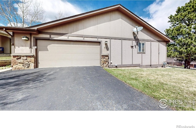 711 Eagle Ln, Estes Park, CO 80517 - view of front of property featuring an attached garage, aphalt driveway, a front yard, and stone siding