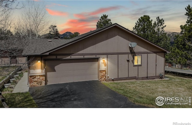 711 Eagle Ln, Estes Park, CO 80517 - view of front of property featuring a lawn, an attached garage, driveway, and stone siding
