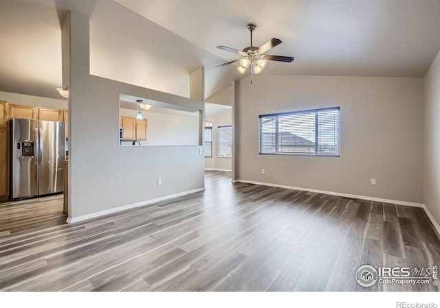 8301 W 18th Street Rd, Greeley, CO 80634 - unfurnished living room featuring a ceiling fan, light wood-style flooring, baseboards, and high vaulted ceiling