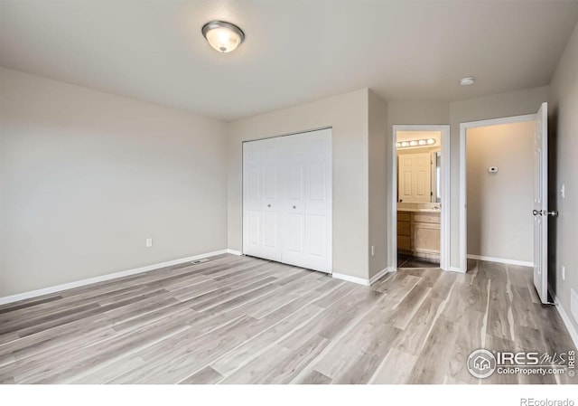 8301 W 18th Street Rd, Greeley, CO 80634 - unfurnished bedroom with light wood finished floors, baseboards, a closet, and ensuite bath