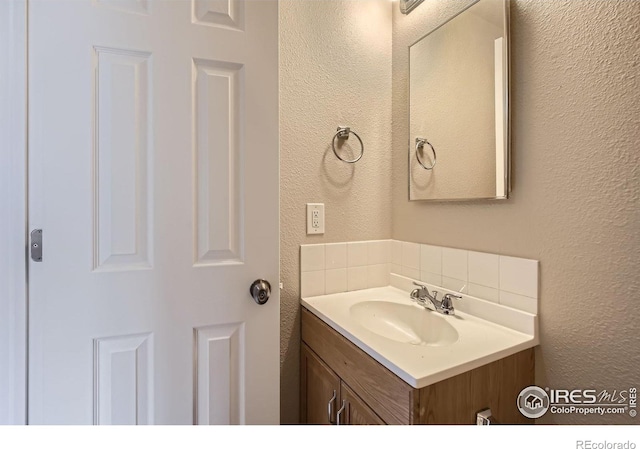 8301 W 18th Street Rd, Greeley, CO 80634 - bathroom featuring a textured wall, backsplash, and vanity