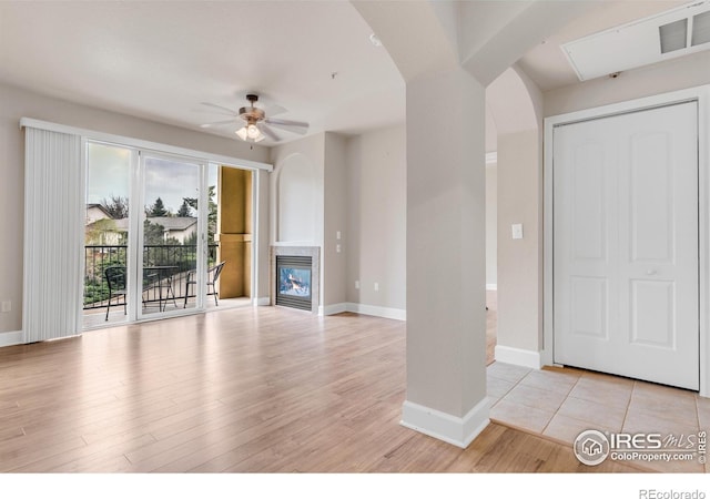 4500 Baseline Rd Unit 3203, Boulder, CO 80303 - unfurnished living room with a ceiling fan, baseboards, a glass covered fireplace, visible vents, and arched walkways