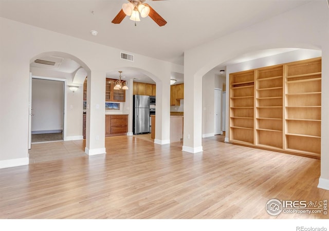 4500 Baseline Rd Unit 3203, Boulder, CO 80303 - unfurnished living room featuring visible vents, light wood finished floors, arched walkways, a ceiling fan, and baseboards