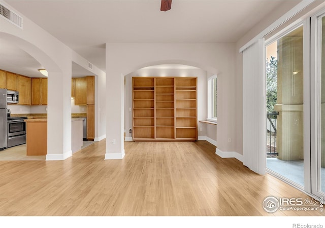 4500 Baseline Rd Unit 3203, Boulder, CO 80303 - unfurnished living room with light wood-type flooring, visible vents, baseboards, built in features, and arched walkways