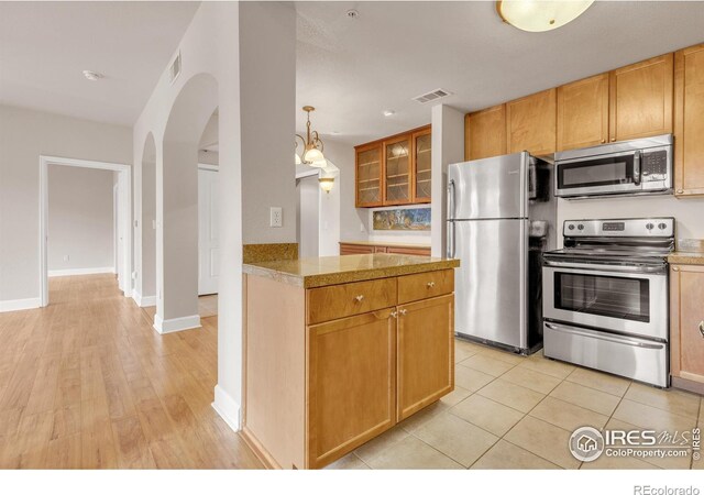 4500 Baseline Rd Unit 3203, Boulder, CO 80303 - kitchen with arched walkways, stainless steel appliances, visible vents, and glass insert cabinets