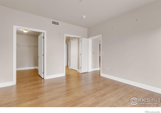 4500 Baseline Rd Unit 3203, Boulder, CO 80303 - unfurnished bedroom featuring light wood-type flooring, a spacious closet, baseboards, and visible vents
