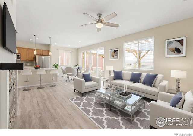 living area with recessed lighting, ceiling fan, and light wood finished floors