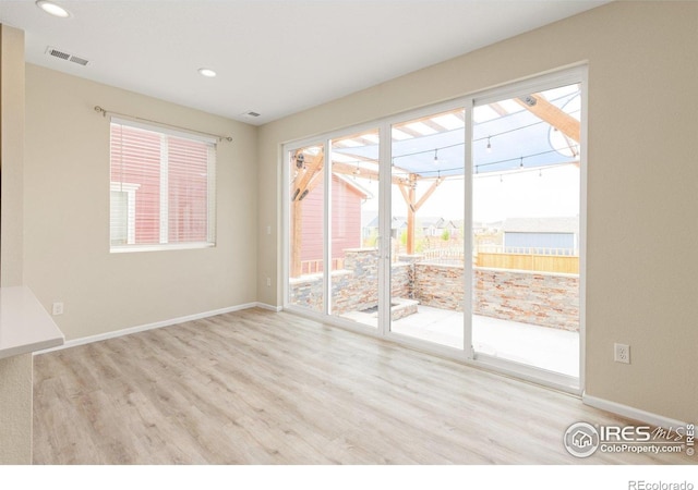 spare room with baseboards, recessed lighting, wood finished floors, and visible vents