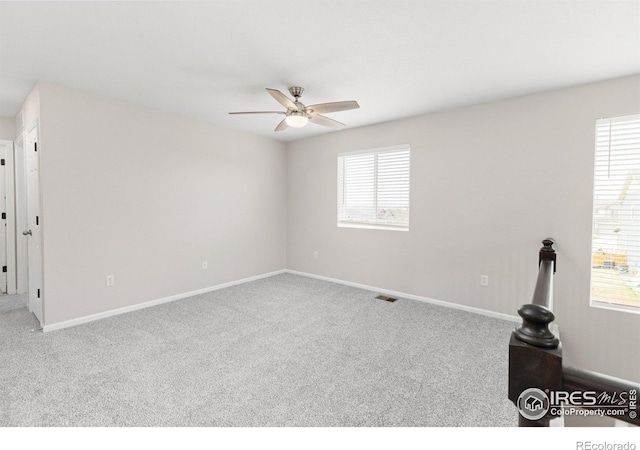spare room with baseboards, carpet, and ceiling fan