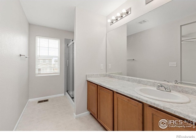 bathroom featuring visible vents, baseboards, a shower stall, and vanity
