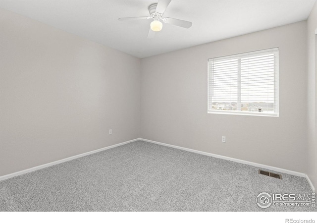 empty room with visible vents, a ceiling fan, baseboards, and carpet floors