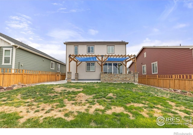 rear view of house with a fenced backyard, a pergola, and a yard