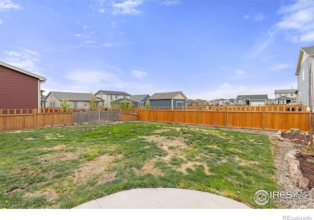 view of yard with a fenced backyard and a residential view