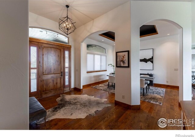 5751 Last Pointe Dr, Windsor, CO 80550 - entryway with wood finished floors, a chandelier, arched walkways, and baseboards