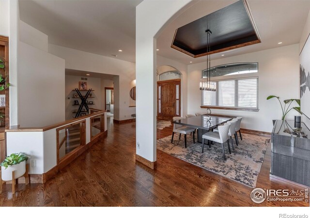 5751 Last Pointe Dr, Windsor, CO 80550 - dining room featuring arched walkways, wood finished floors, a chandelier, baseboards, and recessed lighting
