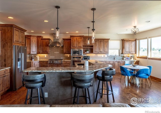 5751 Last Pointe Dr, Windsor, CO 80550 - kitchen featuring appliances with stainless steel finishes, wall chimney exhaust hood, brown cabinetry, dark wood-style flooring, and a sink