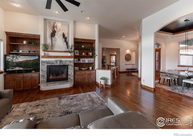 5751 Last Pointe Dr, Windsor, CO 80550 - living area with a ceiling fan, arched walkways, dark wood finished floors, and a fireplace