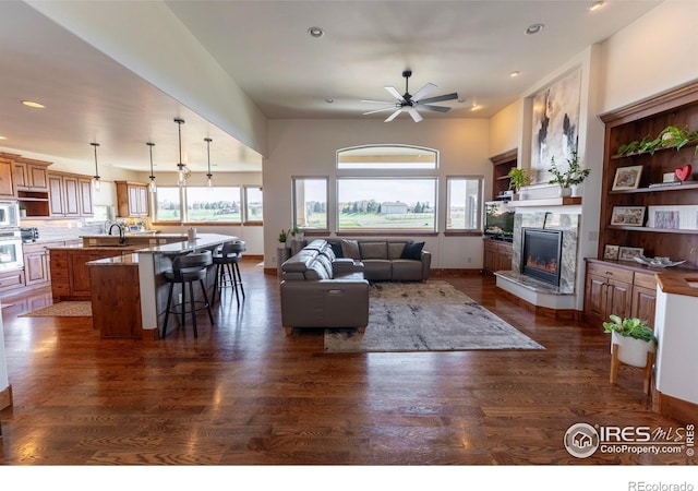 5751 Last Pointe Dr, Windsor, CO 80550 - living room featuring dark wood-style floors, ceiling fan, a fireplace, recessed lighting, and baseboards
