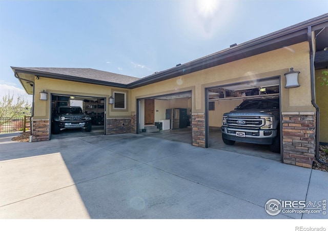 5751 Last Pointe Dr, Windsor, CO 80550 - view of home's exterior featuring stone siding, concrete driveway, an attached garage, and stucco siding
