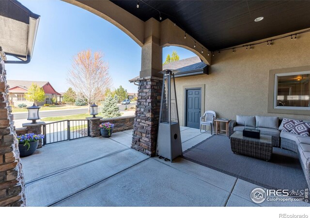 5751 Last Pointe Dr, Windsor, CO 80550 - covered porch featuring outdoor lounge area