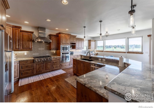 5751 Last Pointe Dr, Windsor, CO 80550 - kitchen featuring wall chimney range hood, stainless steel appliances, a sink, dark wood-type flooring, and brown cabinetry