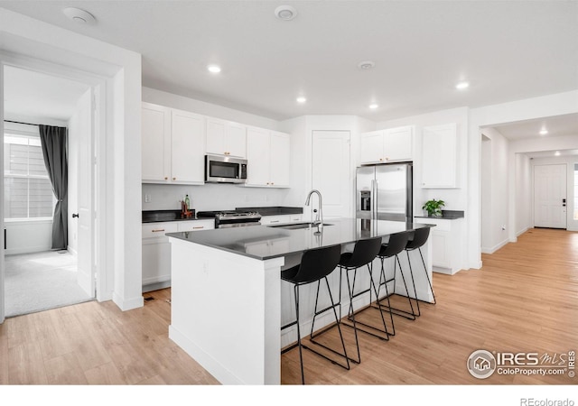 840 Clover Loop, Lafayette, CO 80026 - kitchen featuring stainless steel appliances, dark countertops, a sink, and light wood-style floors