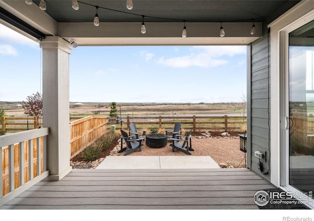 840 Clover Loop, Lafayette, CO 80026 - wooden terrace with an outdoor fire pit, fence, and a rural view