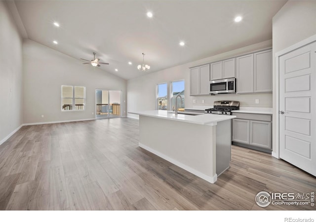 196 Bird Way, Lochbuie, CO 80603 - kitchen with stainless steel appliances, gray cabinets, a kitchen island with sink, recessed lighting, and light wood-style floors