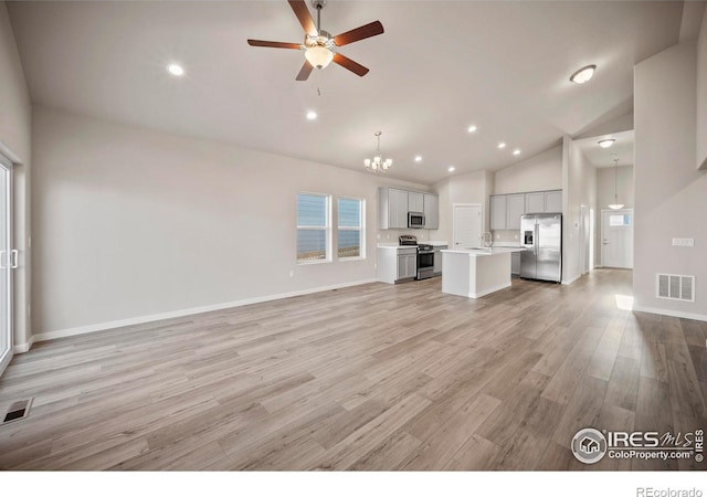 196 Bird Way, Lochbuie, CO 80603 - unfurnished living room with a chandelier, lofted ceiling, ceiling fan, light wood finished floors, and recessed lighting