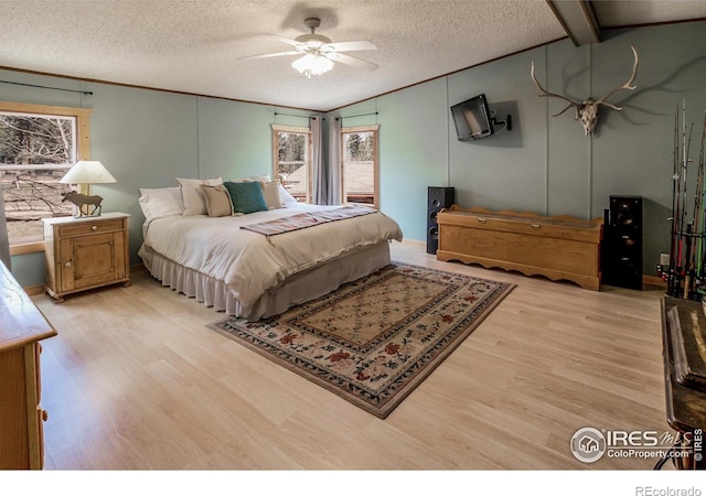 bedroom featuring a textured ceiling, lofted ceiling, ceiling fan, and light wood finished floors
