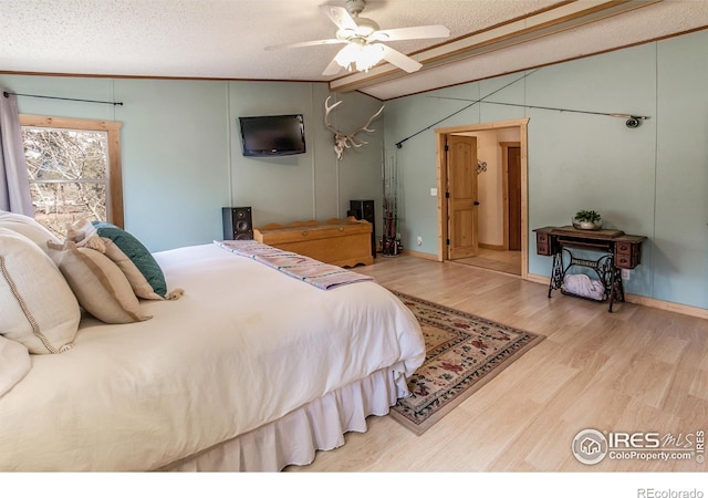 bedroom featuring wood finished floors, a textured ceiling, ceiling fan, and lofted ceiling