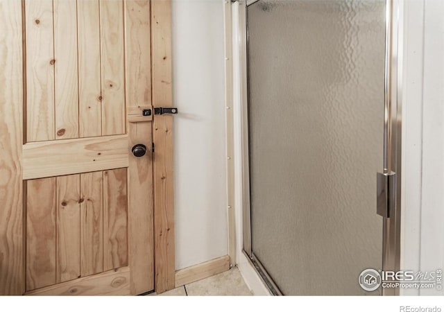 bathroom featuring tile patterned flooring and a shower stall