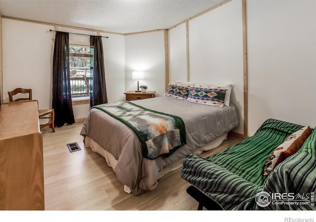 bedroom featuring a textured ceiling and light wood-style flooring