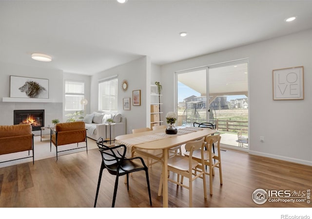 1312 Loraine Cir S, Lafayette, CO 80026 - dining room with a tiled fireplace, wood finished floors, and a wealth of natural light