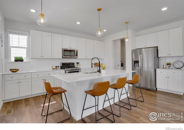 1312 Loraine Cir S, Lafayette, CO 80026 - kitchen featuring a sink, stainless steel appliances, backsplash, and a breakfast bar