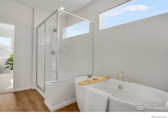 1312 Loraine Cir S, Lafayette, CO 80026 - bathroom featuring wood finished floors, a stall shower, and a soaking tub