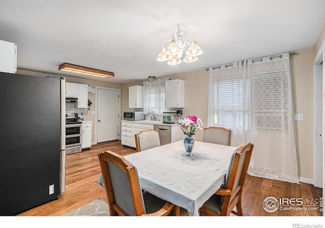 dining area featuring a chandelier and light wood-style floors