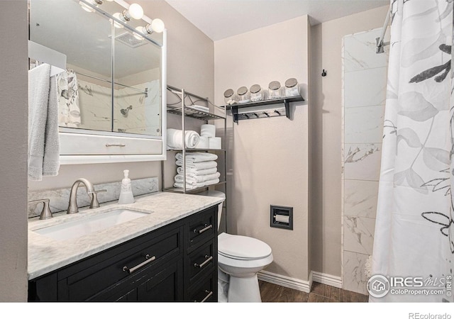 bathroom with vanity, a shower with shower curtain, toilet, wood finished floors, and baseboards