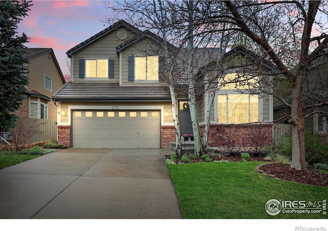 view of front of home with brick siding, a garage, a lawn, and driveway