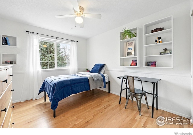bedroom with a ceiling fan, baseboards, and light wood finished floors