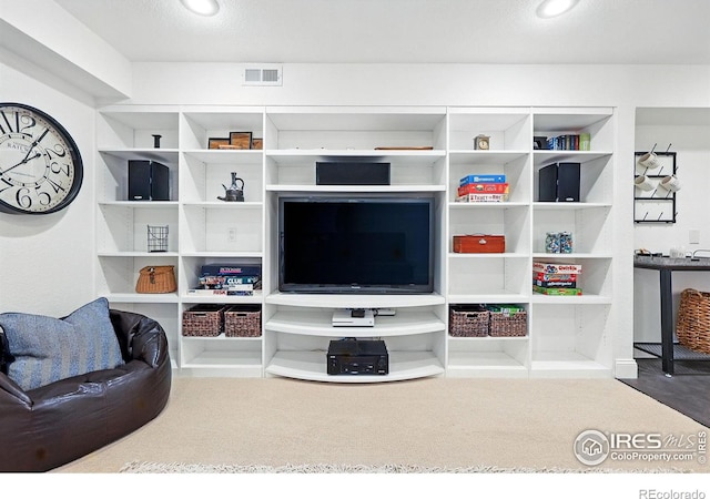living area featuring carpet floors and visible vents