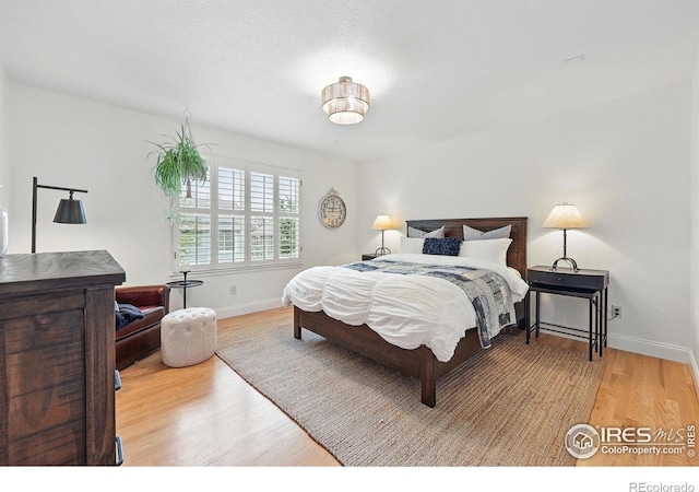 bedroom with baseboards and wood finished floors
